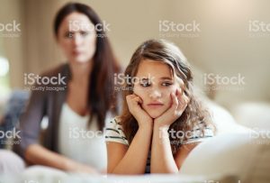 Cropped shot of a young girl being reprimanded by her mother at home